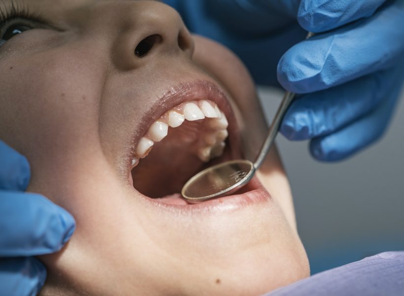Close up of dentist during a dental intervention with a patient. Dentist Concept